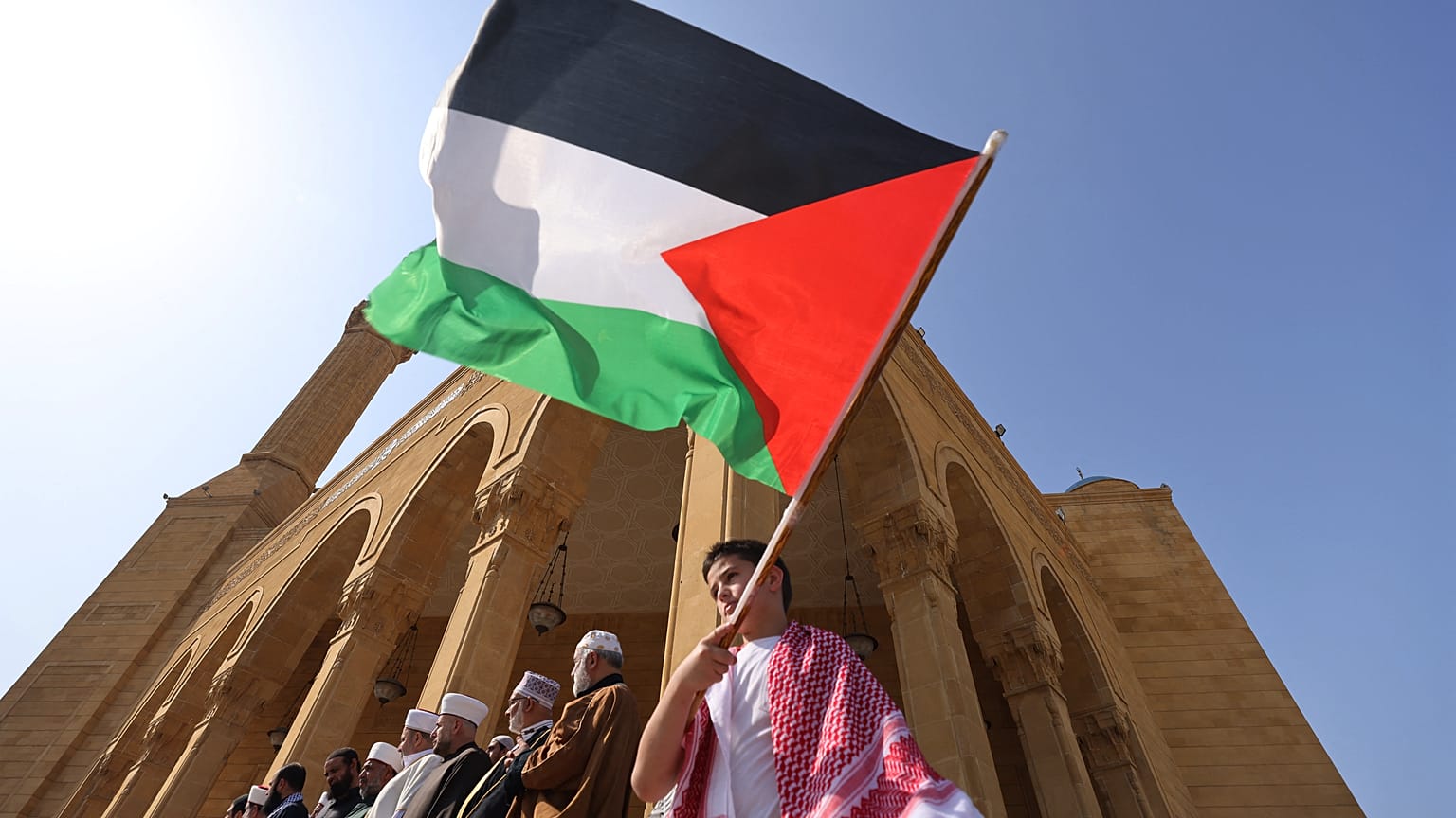 طفل يرفع العلم الفلسطيني أمام جامع الأمين في بيروت - لبنان. 2023/10/29