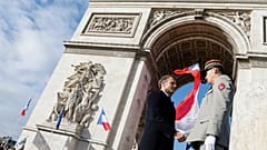 French President Emmanuel Macron shakes hands with FMilitary Governor of Paris and Army Corps General Christophe Abad (R) after a ceremony at the Tomb of the Unknown Soldier