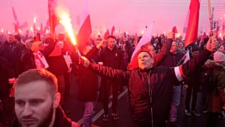 People hold flares as they take part in a yearly march on Poland's Independence Day holiday in Warsaw, Poland, on Saturday, Nov. 11, 2023.