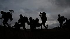 A journalist runs with Ukrainian infantrymen during a training with French soldiers, in France, Tuesday, Nov. 7, 2023.