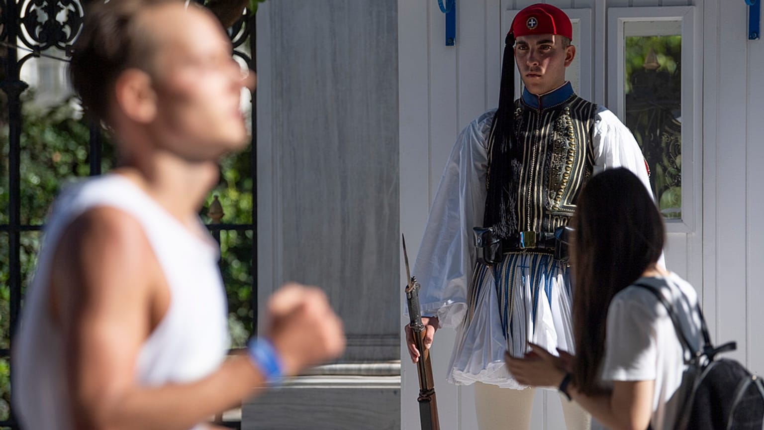 Un soldado de la guardia presidencial observa el paso de un corredor participante en la 40ª edición del denominado 'Maratón Auténtico de Atenas', en Grecia.