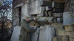 Ukrainischer Soldat untersucht von russischen Truppen zurückgelassene Munition im Dorf Kiseliovka nahe Chersons (10. November 2023)