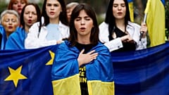 Женщины поют, завернувшись в флаг Украины