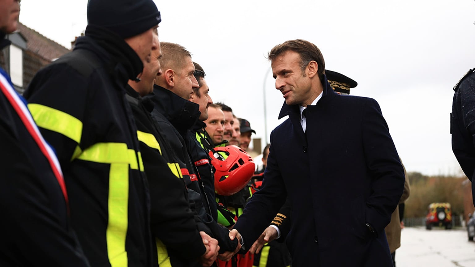 France's President Emmanuel Macron, shakes hands with members of rescue teams in Blendecques, northern France, Tuesday, Nov. 14, 2023. 