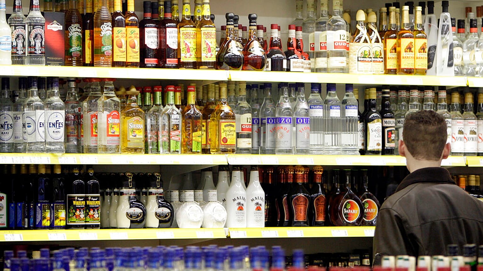  A young man stands in front of a shelve with hard liquor at a beverage market in Gelsenkirchen, western Germany, June 15, 2007. 