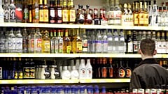  A young man stands in front of a shelve with hard liquor at a beverage market in Gelsenkirchen, western Germany, June 15, 2007. 