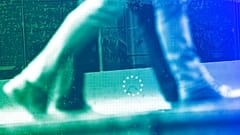 People walk past a European Union logo in a security fence at the European quarter in Brussels, October 2019