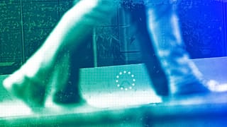 People walk past a European Union logo in a security fence at the European quarter in Brussels, October 2019
