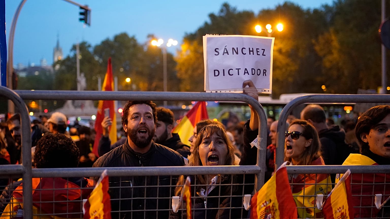 La gente protesta detrás de las barreras de seguridad durante el debate de investidura, el miércoles 15 de noviembre de 2023.
