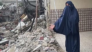امرأة فلسطينية في رفح أمام ركام بيتها الذي قصفه الجيش الإسرائيلي
