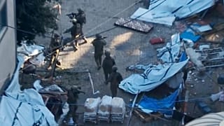 Israeli soldiers walk in the area of Al-Shifa hospital in Gaza City in footage purporting to show two army brigades operating on the ground.
