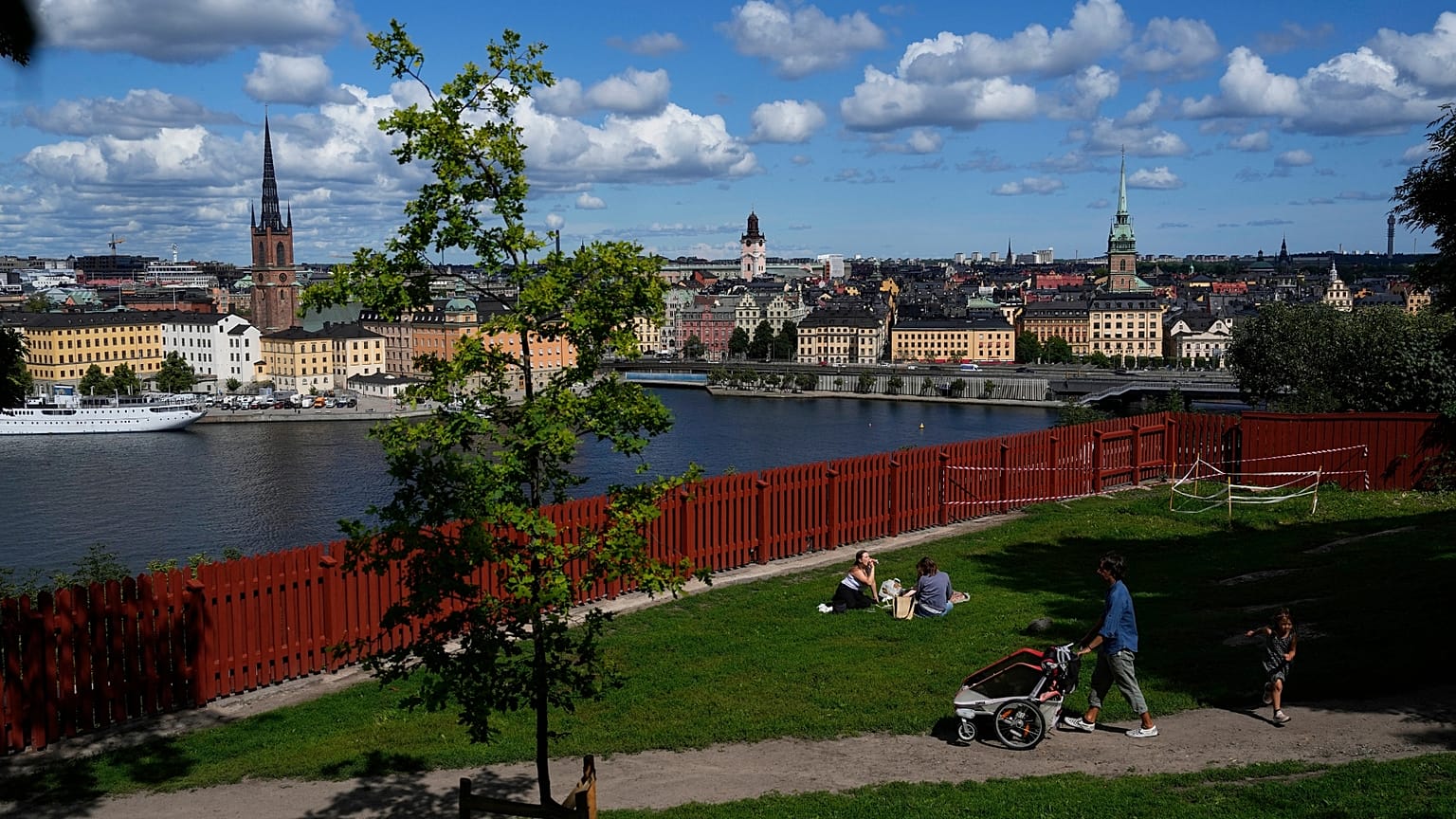 People enjoy sunny weather in a park in Stockholm, Sweden.