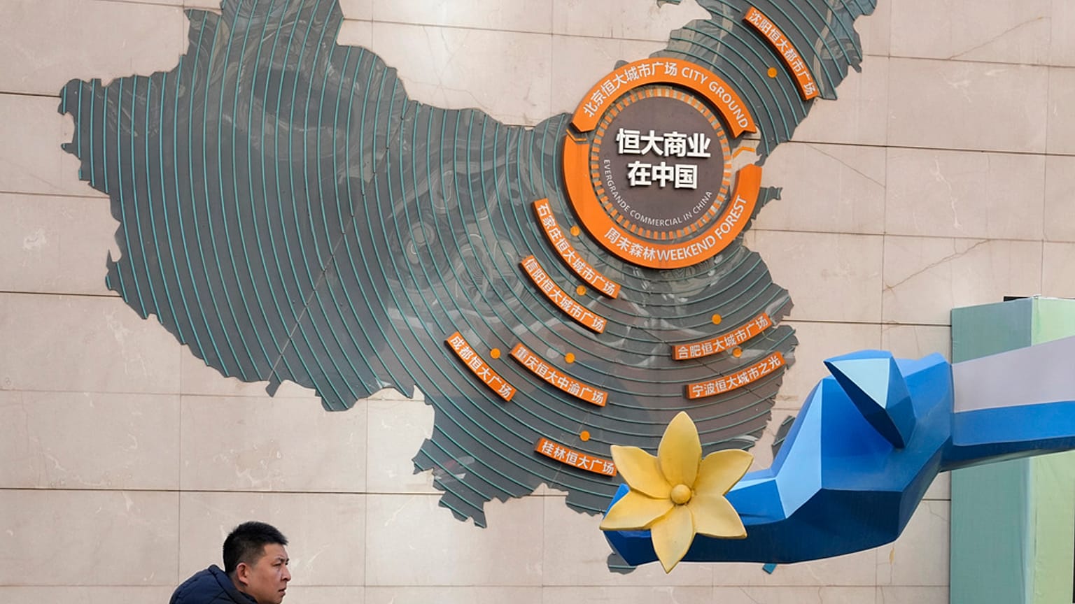 A man passes by a map depicting Evergrande's commercial projects in China at a mall in Beijing, China on Dec. 7, 2021.