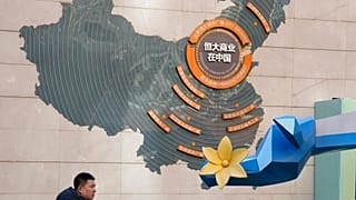 A man passes by a map depicting Evergrande's commercial projects in China at a mall in Beijing, China on Dec. 7, 2021.