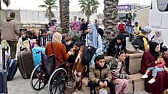 فلسطينون ينتظرون عند معبر رفح الحدودي مع مصر.
