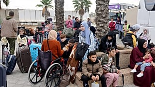 فلسطينون ينتظرون عند معبر رفح الحدودي مع مصر.