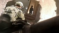 In this image taken from video released by Israeli Defense Forces, Thursday, Nov 16, 2023, Israeli soldiers wind their way through a hole in a building in Gaza
