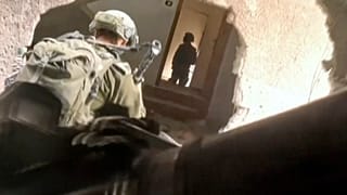 In this image taken from video released by Israeli Defense Forces, Thursday, Nov 16, 2023, Israeli soldiers wind their way through a hole in a building in Gaza