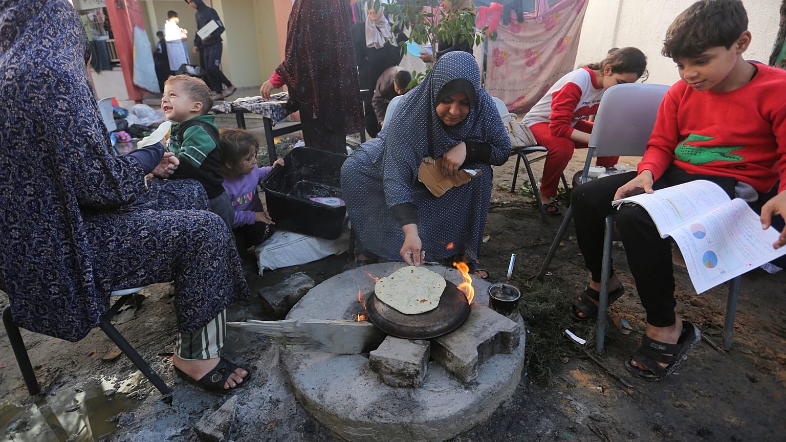 أم فلسطينية لاجئة تعد الخبز في رفح