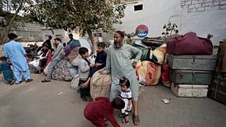 أفغان ينتظرون وصول وسائل النقل إلى وطنهم في كراتشي