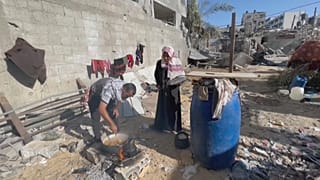 Amal e Imed cocinando para su famila en las ruinas de lo que fue su hogar