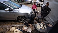 Εκτοπισμένοι Παλαιστίνιοι ετοιμάζουν ψωμί σε ανοιχτό χώρο στη Γάζα