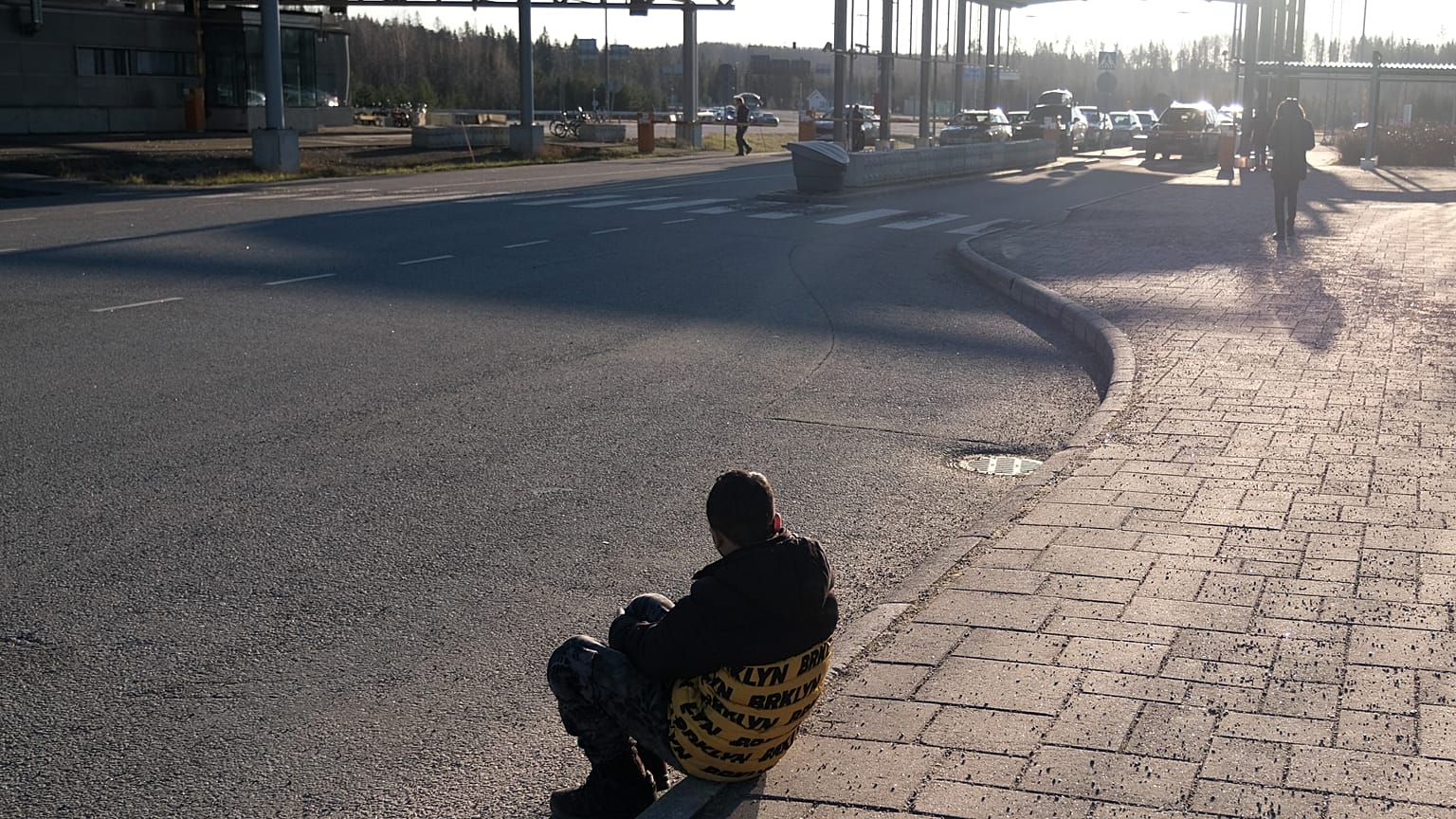 Egy menedékkérő ül a földön a Finnország és Oroszország közötti Nuijamaa határátkelőnél.