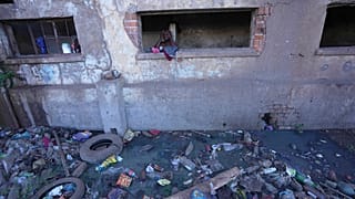 Мужчина принимает душ в одном мз домов Хараре, Зимбабве. 18 ноября 2023.