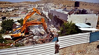 Un hombre observa la demolición de una casa palestina en un barrio de Jerusalén Este, a finales de mayo de 2013.