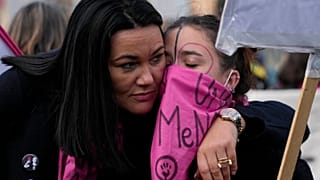 Des manifestants s'étreignent lors d'une manifestation contre la violence envers les femmes, à Rome, le samedi 27 novembre 2021. 