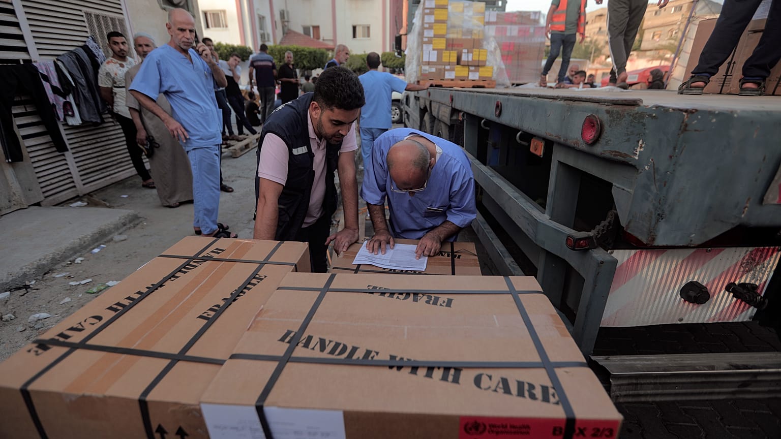  طاقم طبي فلسطيني يفرغ صناديق أدوية من شاحنة وصلت إلى مجمع الناصر الطبي، خان يونس قطاع غزة.