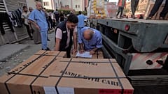  طاقم طبي فلسطيني يفرغ صناديق أدوية من شاحنة وصلت إلى مجمع الناصر الطبي، خان يونس قطاع غزة.