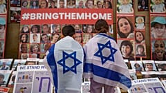 FILE - Children look at photographs of Israelis kidnapped by Hamas during a rally joined by hundreds in solidarity with Israel in Romania, 2023. 