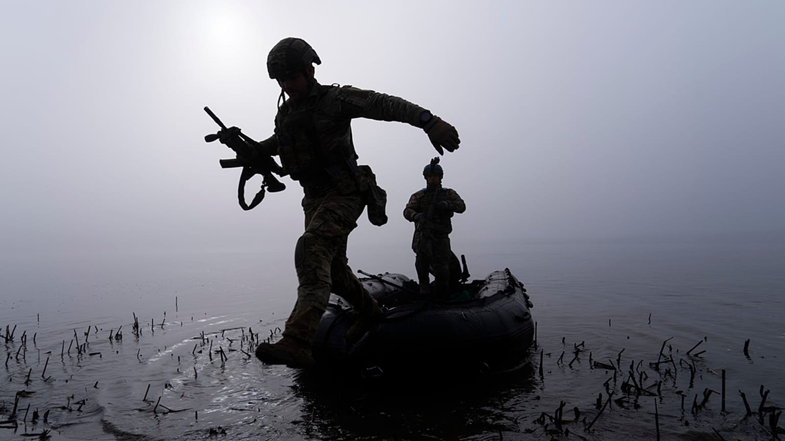 Un soldat ukrainien sautant d'un bateau sur la rive de la rivière Dniepr près de Kherson, Ukraine, le dimanche 15 octobre 2023.