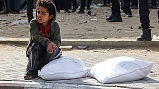طفل فلسطيني بالقرب من أكياس الطحين رفح قطاع غزة