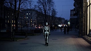 Eine Person in Skelett-Verkleidung läuft entlang einer Ladenzeile in Kiew, Ukraine. 21. November 2023.