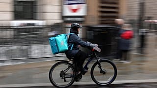 A Deliveroo rider cycling down the road
