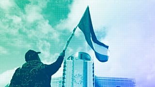 Protestors wave flags as they march past EU institutions during a demonstration in Brussels, in solidarity with the Palestinian people in Gaza, October 2023