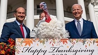 President Joe Biden stands next to Liberty, one of the two national Thanksgiving turkeys, after pardoning them during a ceremony on the South Lawn of the White House