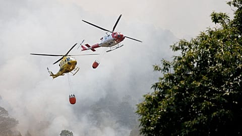 Firefighting helicopters fly over Aguamansa, as wildfires rage out of control on the island of Tenerife, Canary Islands, Spain, 18 August 2023. 
