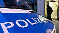 Berlin-Adlershof'ta bir baskın sırasında bir polis aracı sokakta duruyor, 23 Kasım 2023, Perşembe. 