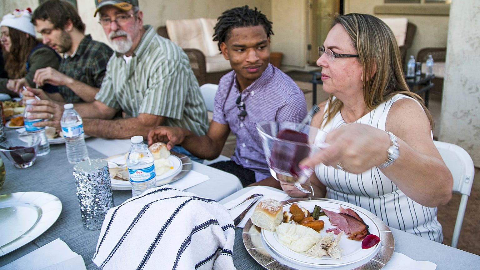 Jamal Hinton, centre, Wanda Dench, right, and her family and friends, have Thanksgiving dinner at Dench's home on 24 November 2016, in Mesa, Arizona.