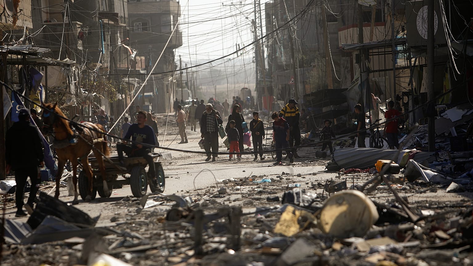 Palestinos inspeccionan sus casas destruidas en la localidad de Kazaa, al este de Khan Younis, al sur de la Franja de Gaza, este viernes 24 de noviembre