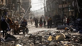 Palestinos inspeccionan sus casas destruidas en la localidad de Kazaa, al este de Khan Younis, al sur de la Franja de Gaza, este viernes 24 de noviembre