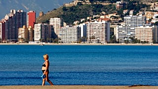 A woman walks on the beach of the Village of Cullera,south of Valencia, Spain, on Thursday, April 3, 2008.