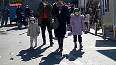 Maskierte Anwohner gehen an einem chinesischen Kinderkrankenhaus in Peking vorbei, Freitag, 24. November 2023.