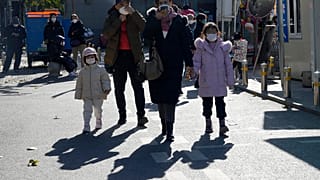 Maskierte Anwohner gehen an einem chinesischen Kinderkrankenhaus in Peking vorbei, Freitag, 24. November 2023.