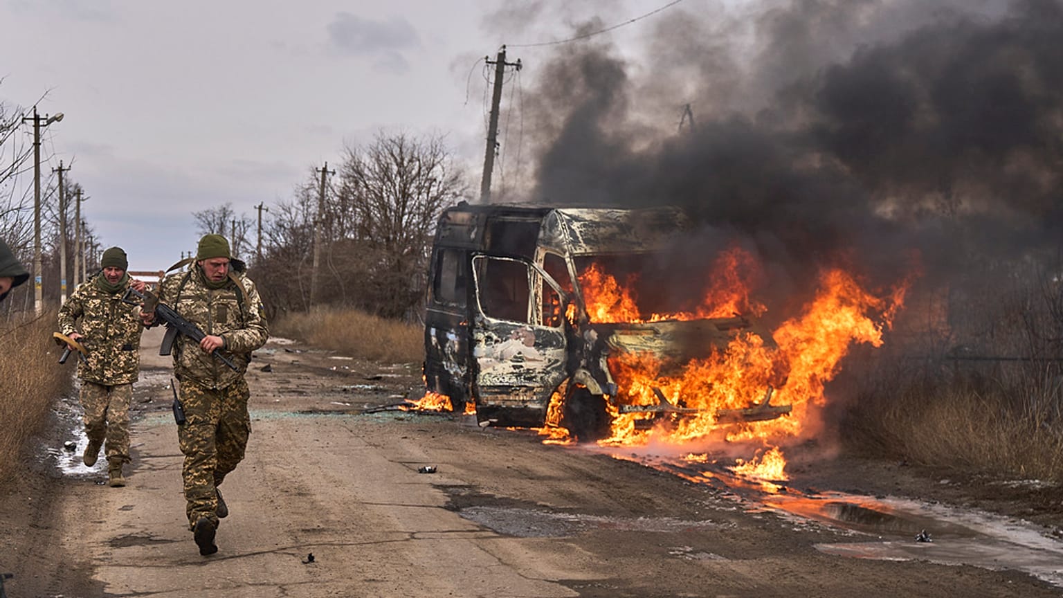 Украинские солдаты автобуса добровольцев, горящего после попадания в него российского беспилотника возле Бахмута, Донецкая область, Украина, четверг, 23 ноября 2023 года