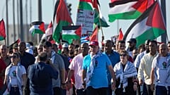 الرئيس الكوبي ميغيل دياز كانيل (وسط) وزوجته ليز كويستا يسيران خلال مظاهرة مؤيدة للفلسطينيين في هافانا