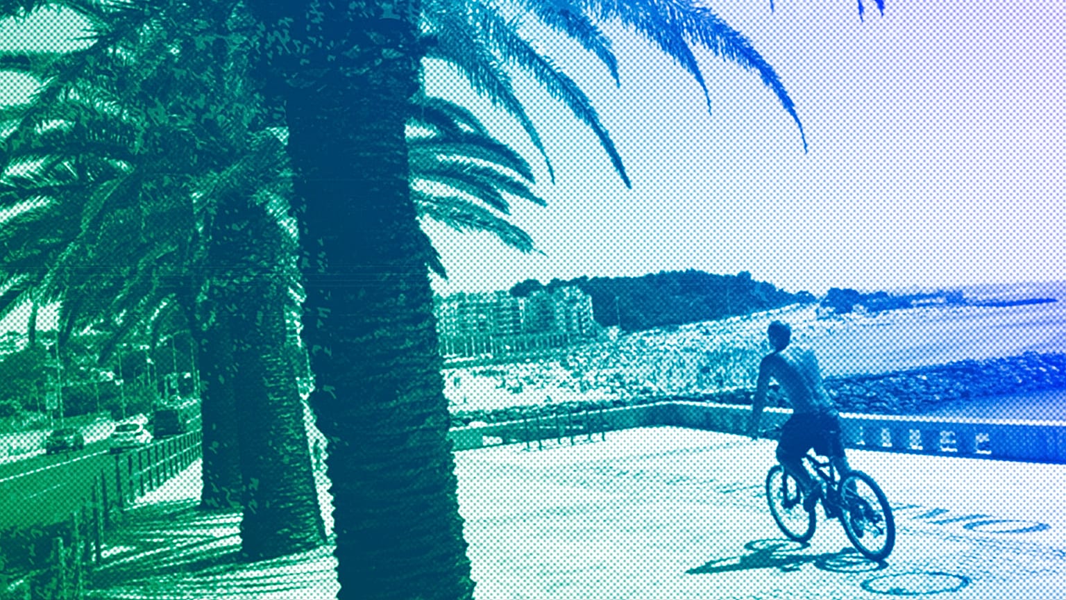 A man rides a bicycle by the beach in Oeiras, just outside Lisbon, July 2023